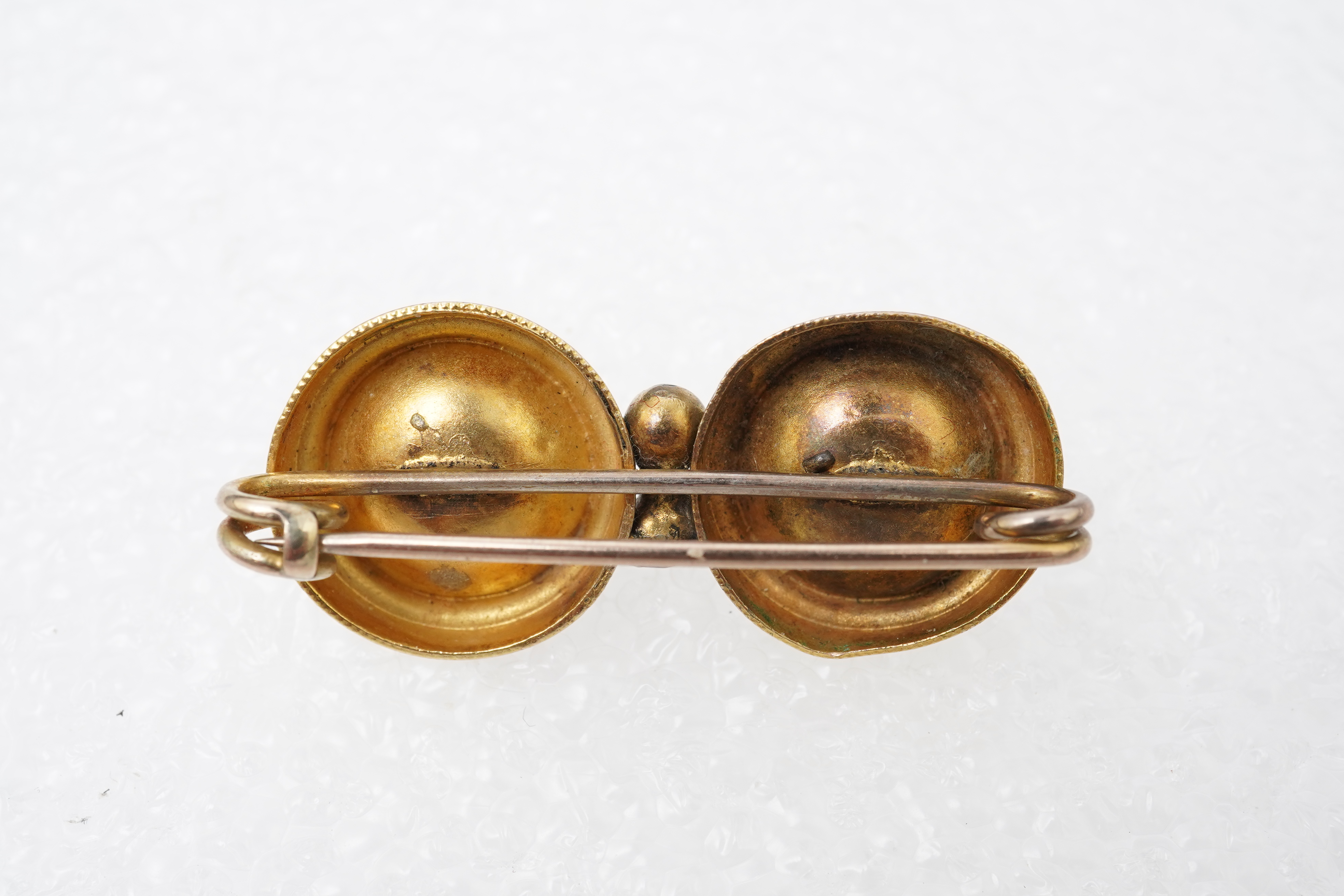 A Victorian ruby and gold double target brooch, late 19th century and later, composed of two roundels set with circular-cut garnets, with wirework details, length 3.7cm, gross weight approximately 3.5 grams